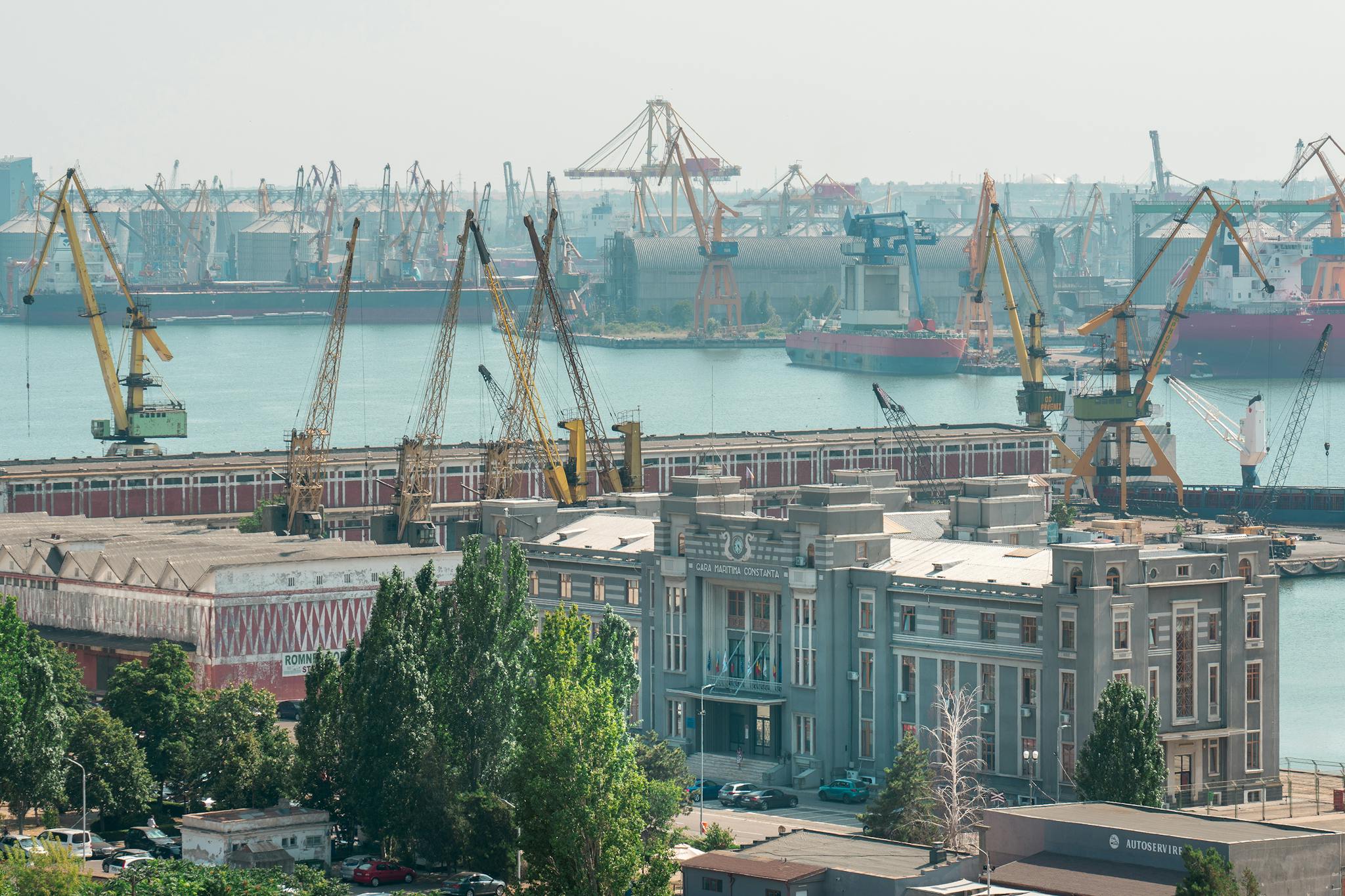 Industrial cranes and buildings at Constanța Port during daytime, Romania's bustling hub.