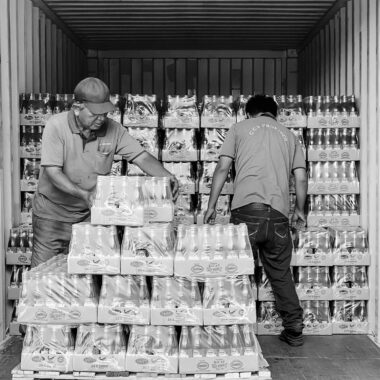 Two workers organize products in a shipping container in Ipoh, Malaysia.